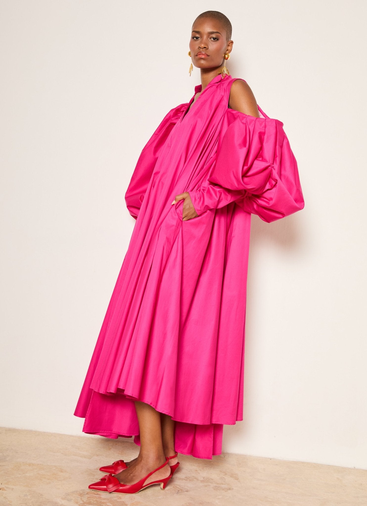 Trapeze Cotton Poplin Gown with oversized puff sleeves, asymmetrical pleated cold shoulder, and side seam pockets, perfect for garden parties, holiday celebrations, resort wear, vacation dress, and formal events